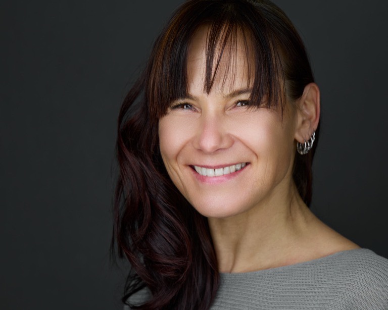 Personal-Branding-Portrait einer Frau mit dunklem Haar vor grauem Hintergrund, fotografiert von Christian Volk