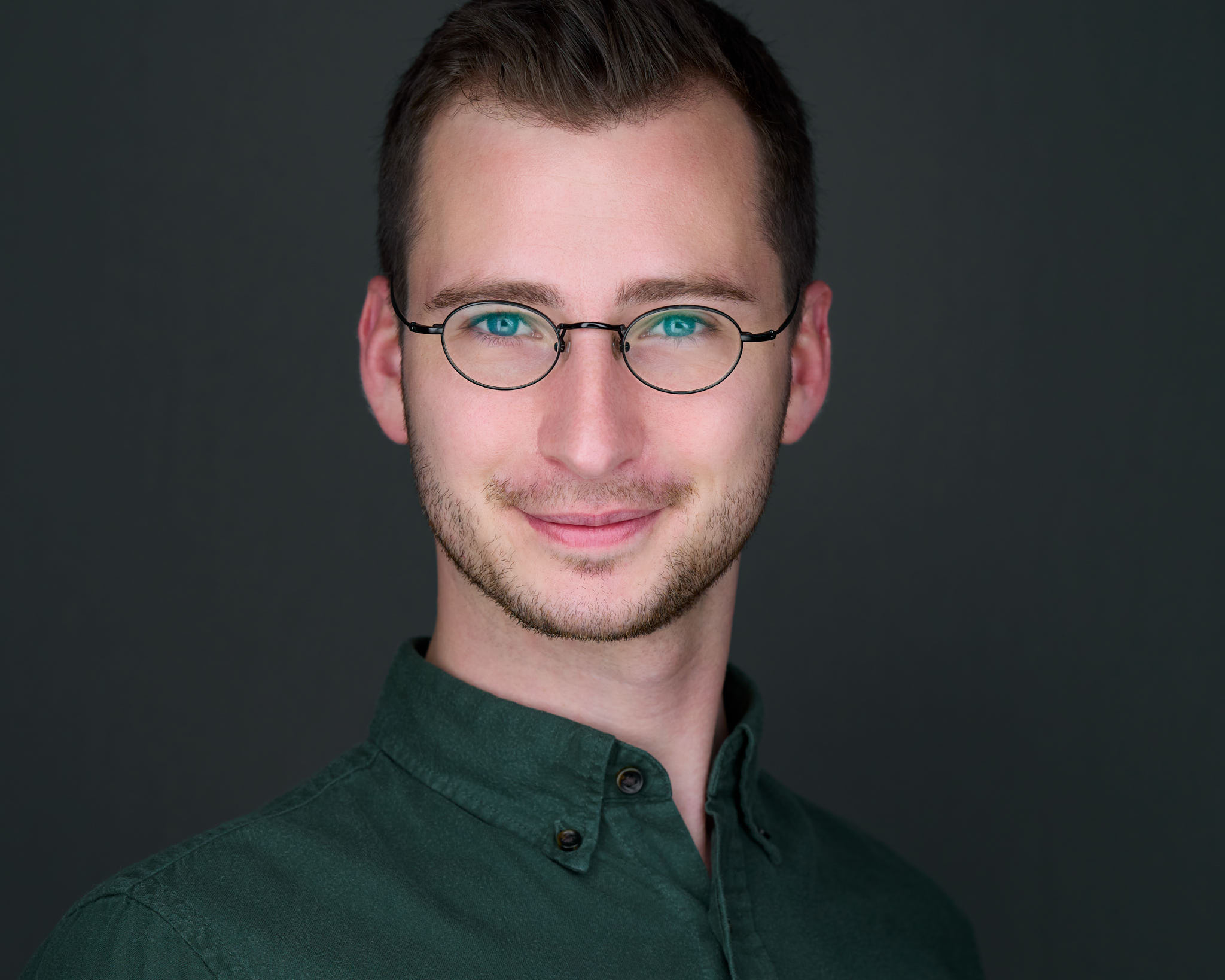 Personal-Branding-Portrait eines jungen Mannes mit Brille und grünem Hemd, fotografiert von Christian Volk