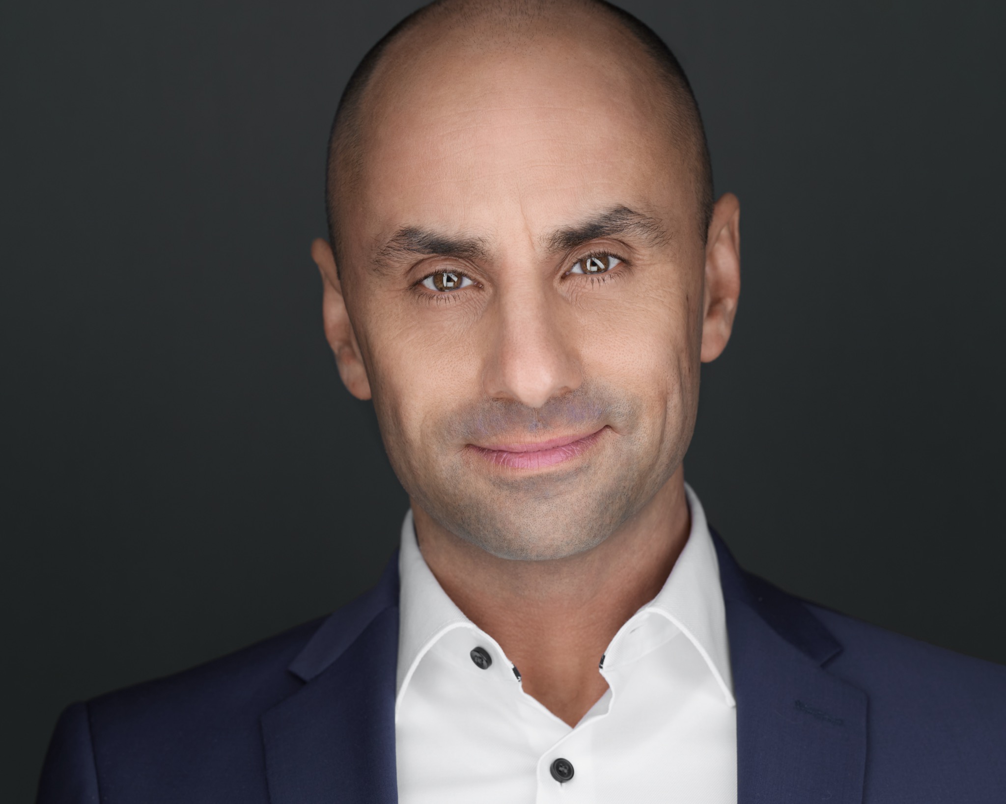 Personal-Branding-Portrait eines Mannes im blauen Anzug vor dunklem Hintergrund, fotografiert von Christian Volk